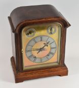 A GERMAN MANTEL CLOCK having a domed brass dial with silvered chapter ring bearing Roman numerals