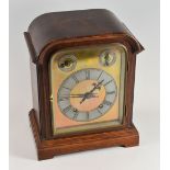 A GERMAN MANTEL CLOCK having a domed brass dial with silvered chapter ring bearing Roman numerals