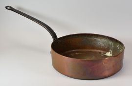AN ANTIQUE IRISH COPPER PAN with long iron looped handle, impressed Maguire & Gatchell, Dublin,