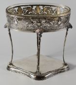 A CONTINENTAL SILVER TABLE CENTREPIECE raised on four bow supports with goat-head and hoof