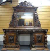 AN IMPOSING OAK MIRROR BACK PEDESTAL SIDEBOARD heavily and impressively carved all-round with
