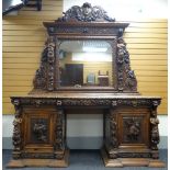 AN IMPOSING OAK MIRROR BACK PEDESTAL SIDEBOARD heavily and impressively carved all-round with