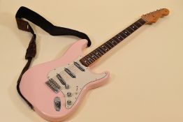 A FENDER STRATOCASTER contour body, pink with white scratchplate together with carry case, serial
