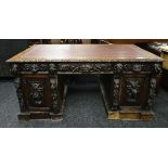 A CARVED OAK PARTNER'S DESK with tooled leather top, 70cms high x 153cms wide