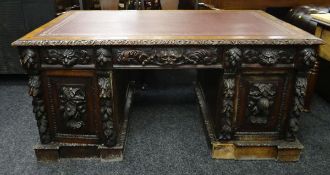 A CARVED OAK PARTNER'S DESK with tooled leather top, 70cms high x 153cms wide