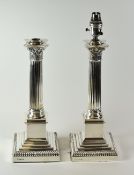 A PAIR OF SILVER LAMP-BASES of Classical architectural form with floral terminals over Corinthian