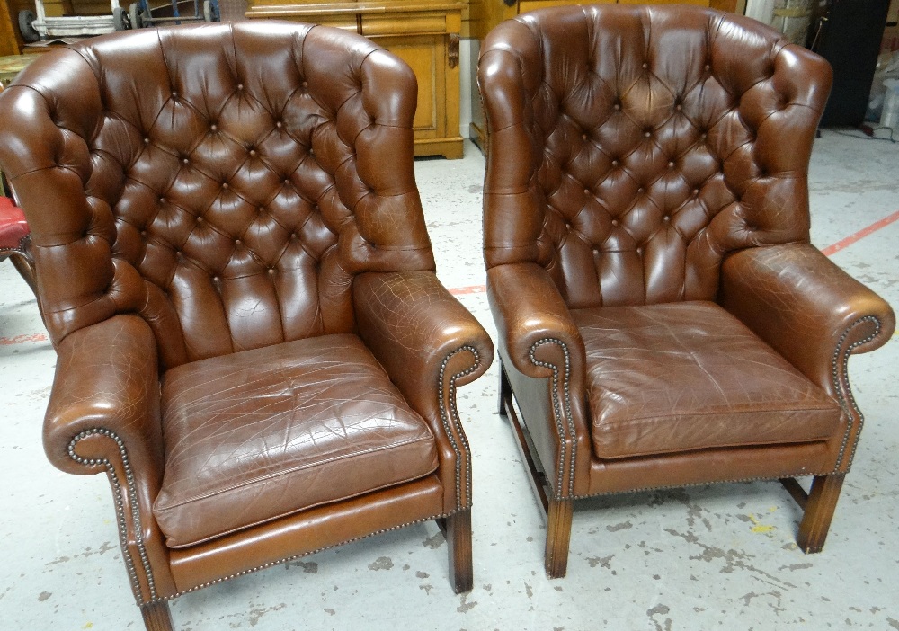 A PAIR OF BUTTONED BROWN LEATHER ARMCHAIRS