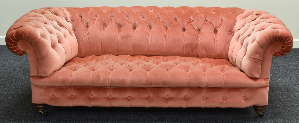 A CHESTERFIELD-STYLE SETTEE in buttoned pink dralon fabric