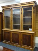 AN OAK BOOKCASE CUPBOARD with three glazed doors above three closed, 250cms high x 222cms wide
