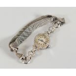 A LADIES VINTAGE COCKTAIL WATCH encrusted with diamonds, the white gold bracelet marked 9ct, the