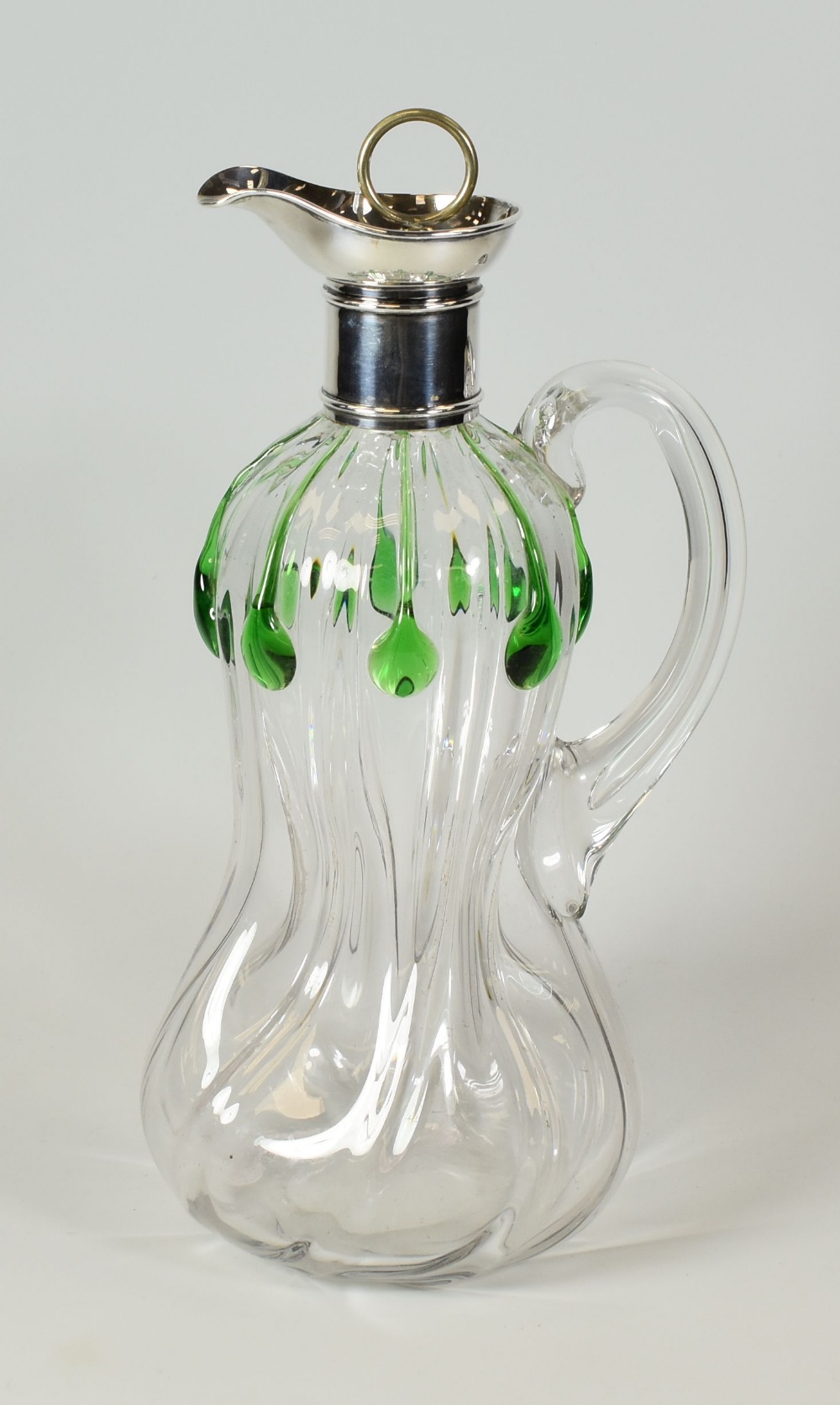 A GLASS DECANTER WITH SILVER COLLAR & SPOUT having a handle and swirling waisted body with green