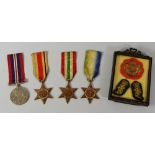 A PARCEL OF WWII MEDALS, unnamed, together with three embroidered military crests in a small easel