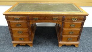 A GILLOWS OF LANCASTER KNEEHOLE DESK in medium coloured oak and having carved detail, tooled leather