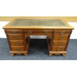 A GILLOWS OF LANCASTER KNEEHOLE DESK in medium coloured oak and having carved detail, tooled leather