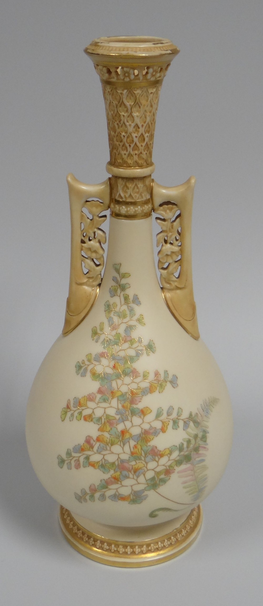 A ROYAL WORCESTER TWIN HANDLED VASE with narrow neck and openwork to the neck and handles on a