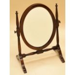 AN EDWARDIAN INLAID MAHOGANY OVAL TOILET MIRROR on a delicate stand, 47cms high