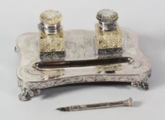 AN EPNS DESK STAND & ANTIQUE FOUNTAIN PEN, the stand having a shaped base raised on four scroll