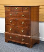 A GEORGE III WALNUT CHEST composed of four graduated long drawers and three short drawers with brass