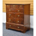 A GEORGE III WALNUT CHEST composed of four graduated long drawers and three short drawers with brass