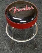 A FENDER GUITAR STOOL on four 'chrome' supports with logo to black and red seat