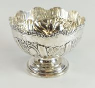 A SILVER MONTEITH raised over a circular foot and with alternating floral and fluted decoration to