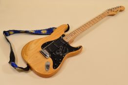 A FENDER ELECTRIC GUITAR varnished wood with black scratchplate together with carry case, serial