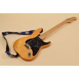 A FENDER ELECTRIC GUITAR varnished wood with black scratchplate together with carry case, serial