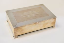 A SILVER CIGARETTE BOX on four corner supports and with machine turned border to the hinged lid
