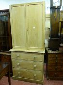 A VICTORIAN STRIPPED PINE TWO DOOR CUPBOARD on a chest of three long drawers with turned wooden