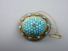 A LARGE OVAL PINCHBECK BROOCH having a filigree and scrolled border with tiny oval aquamarines and