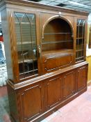 A REPRODUCTION MAHOGANY DISPLAY SIDEBOARD having an arched central open shelf area with flanking