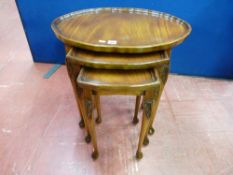 A SET OF THREE REPRODUCTION MAHOGANY OCCASIONAL TABLES with shaped tray type tops and carved leg