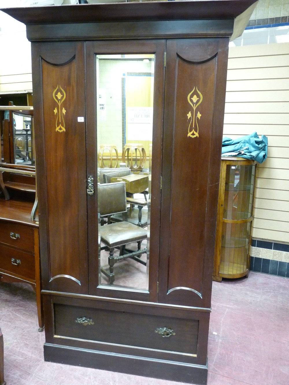 A LATE EDWARDIAN MAHOGANY SINGLE WARDROBE having a centre door with bevelled glass panel and Art