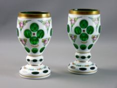 A PAIR OF BOHEMIA OVERLAID GLASS GOBLETS, gilt rimmed with further banding on facet cut white to