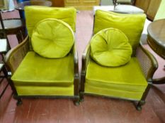 A PAIR OF EARLY 20th CENTURY BERGERE ARMCHAIRS, the walnut frames with cane backs and sides, loose