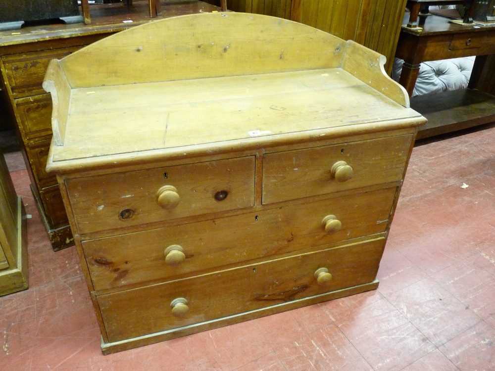A VICTORIAN STRIPPED PINE CHEST of two long and two short drawers having a shaped back rail and