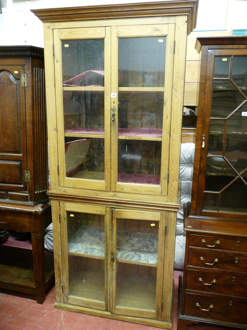 A VICTORIAN STRIPPED PINE TWO PIECE STANDING CUPBOARD, the pairs of doors having glazed panels, 85