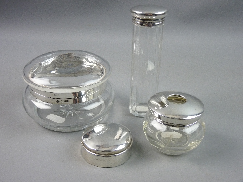 FOUR SILVER DRESSING TABLE ITEMS to include a silver rimmed glass powder bowl and cover, two further