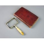 AN IVORY HANDLED MAGNIFYING GLASS in book shaped holder, the rectangular magnifier in a velvet lined