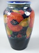 A 16cms HIGH MOORCROFT POMEGRANATE BALUSTER VASE decorated on a cobalt ground, impressed and painted