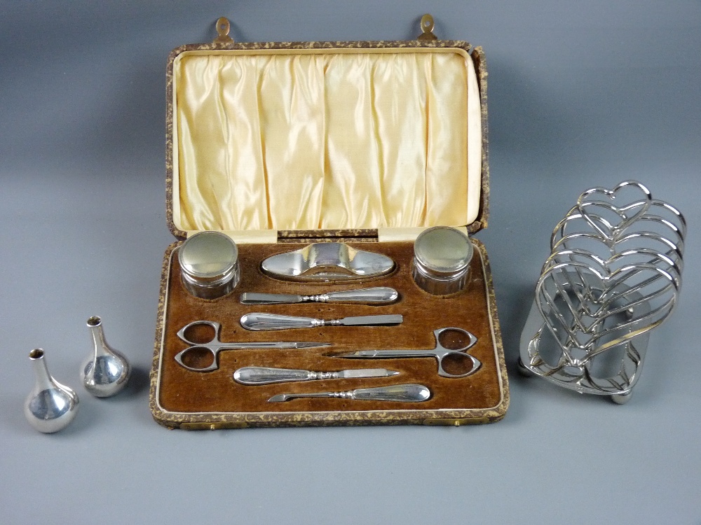 AN ELECTROPLATE CASED NINE PIECE MANICURE SET, a heart shaped toast rack and two Danish bottle