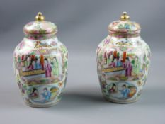 A PAIR OF CHINESE FAMILLE ROSE DECORATED JARS WITH COVERS, the bodies decorated with miscellaneous