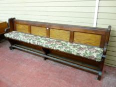 A PITCH PINE CHURCH/SCHOOL PEW having four inset panels to the back and an open slatted base, 248