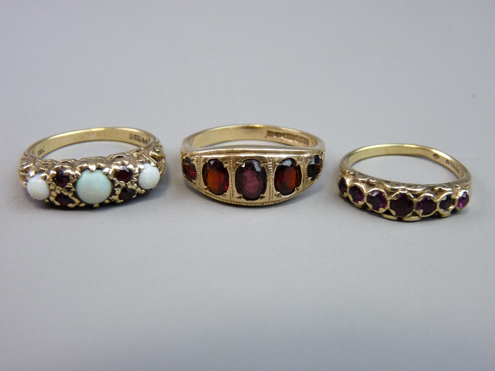 THREE NINE CARAT GOLD DRESS RINGS to include one opal and garnet and two further garnet settings,
