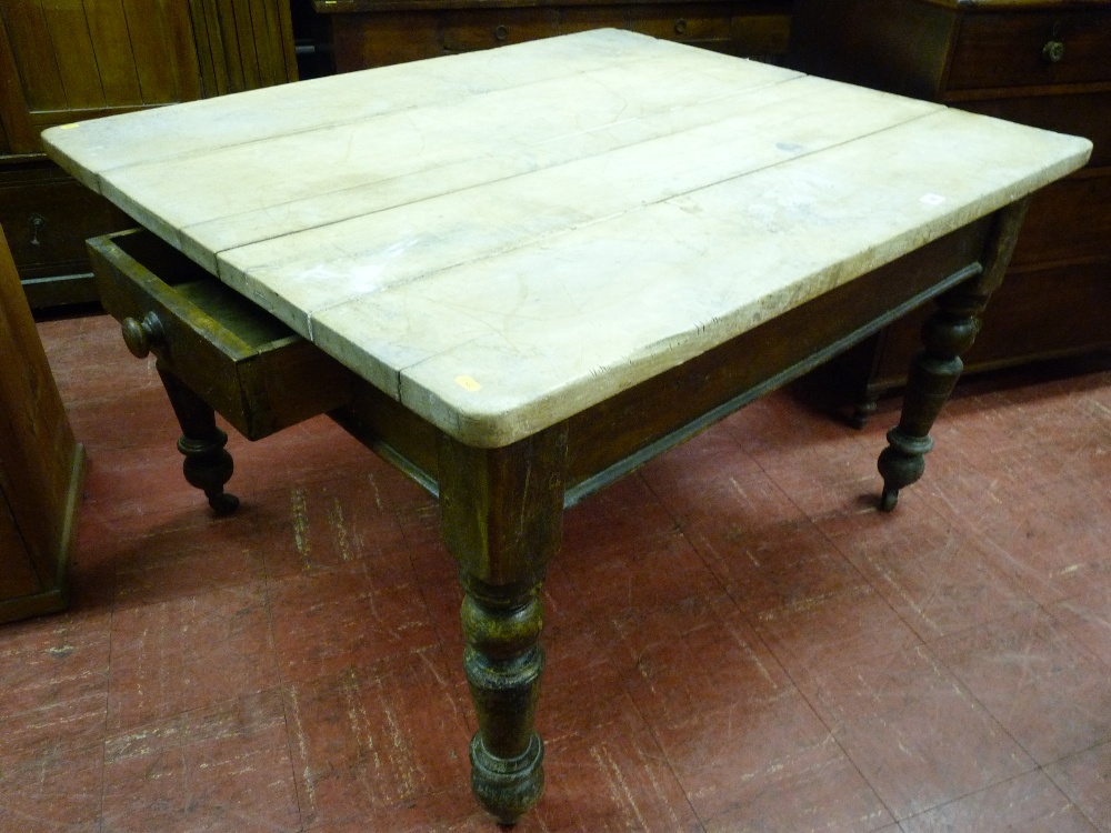 AN OBLONG TOPPED PINE FARMHOUSE TABLE having an opening drawer at either end and turned corner