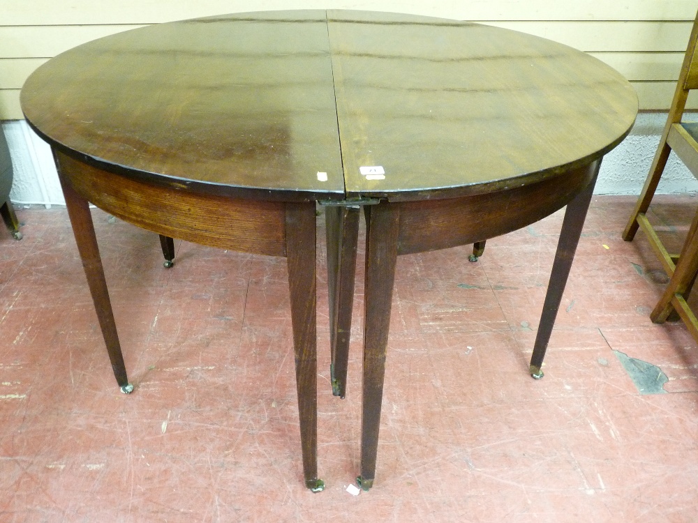 A GEORGIAN MAHOGANY DINING TABLE of two half moon sections with centre leaf and square tapered