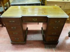 AN EDWARDIAN MAHOGANY KNEEHOLE DESK, the top edge moulding with inverted breakfront and single