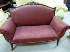 A LATE VICTORIAN CARVED MAHOGANY SALON SETTEE, the leaf carved top rail with flaming urn centre,