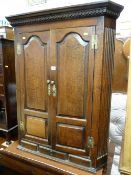 A LATE 18th/EARLY 19th CENTURY OAK HANGING WALL CUPBOARD having a dentil cornice and a pair of doors