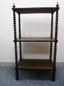 A VICTORIAN ROSEWOOD THREE TIER WHATNOT with finial corner caps and bobbin turned supports to the